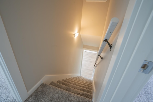 stairway featuring carpet flooring and baseboards