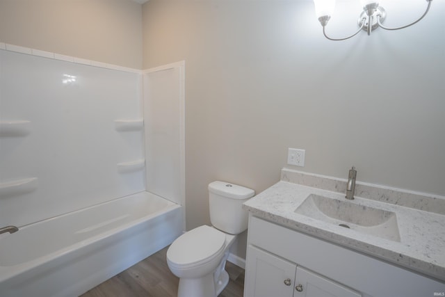 bathroom featuring toilet, washtub / shower combination, wood finished floors, and vanity