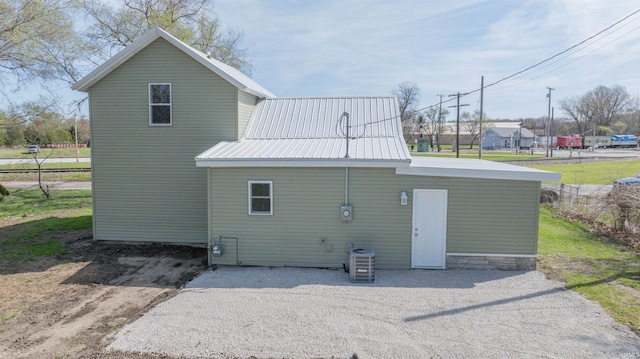 rear view of property featuring metal roof and central air condition unit