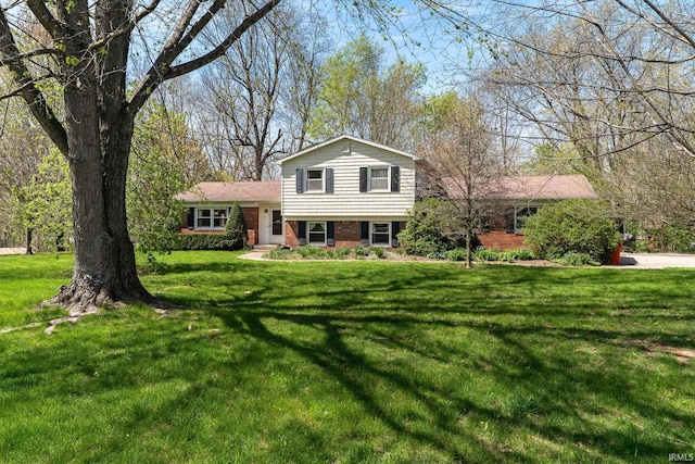 tri-level home with a front yard and brick siding