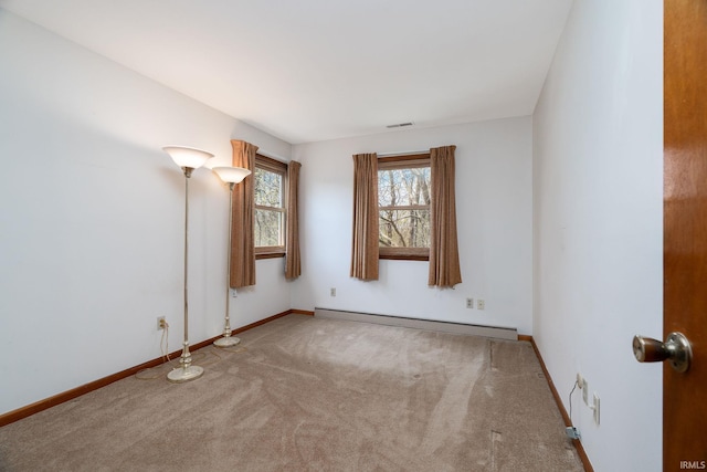 unfurnished room with visible vents, baseboards, a baseboard heating unit, and carpet floors