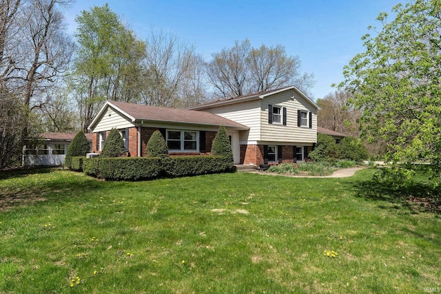 tri-level home with a front yard and brick siding