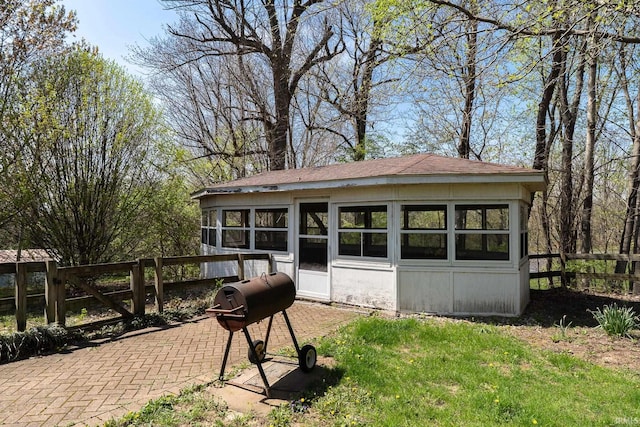 back of property featuring fence and a lawn