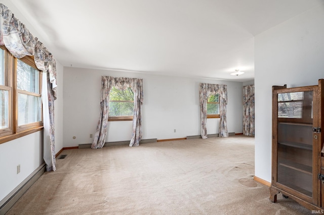 carpeted empty room with visible vents, baseboard heating, and baseboards