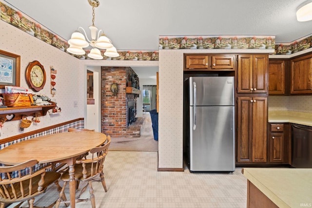 kitchen featuring wallpapered walls, dishwasher, a notable chandelier, and freestanding refrigerator
