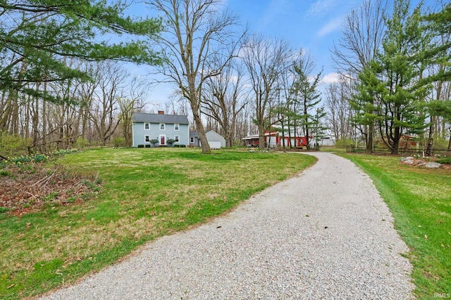 exterior space with a lawn, an outdoor structure, and gravel driveway