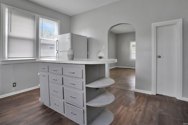 314 S Welworth Ave, Evansville, IN 47714 - kitchen with dark wood-style flooring, open shelves, gray cabinetry, arched walkways, and freestanding refrigerator
