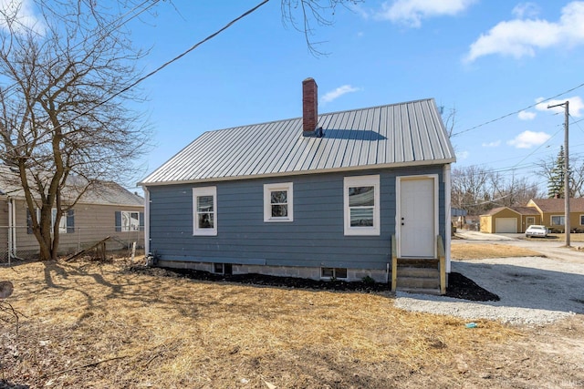 4121 Smith St, Fort Wayne, IN 46806 - rear view of house with metal roof, fence, entry steps, and a chimney