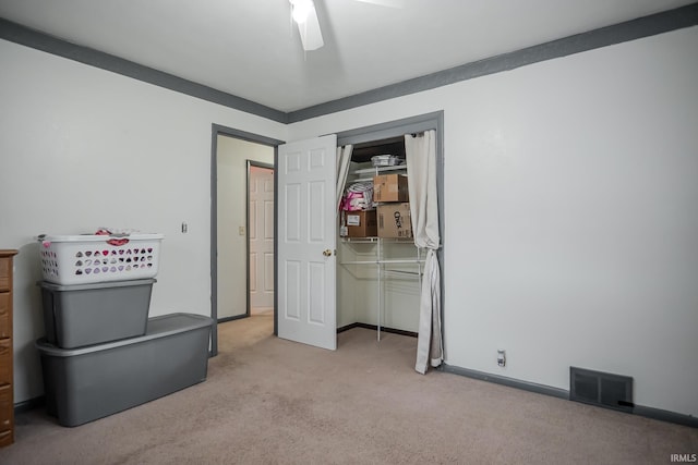 unfurnished bedroom with light colored carpet, visible vents, a closet, baseboards, and a ceiling fan