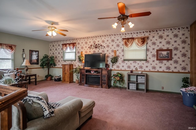 carpeted living room with baseboards, ceiling fan, wallpapered walls, and a fireplace