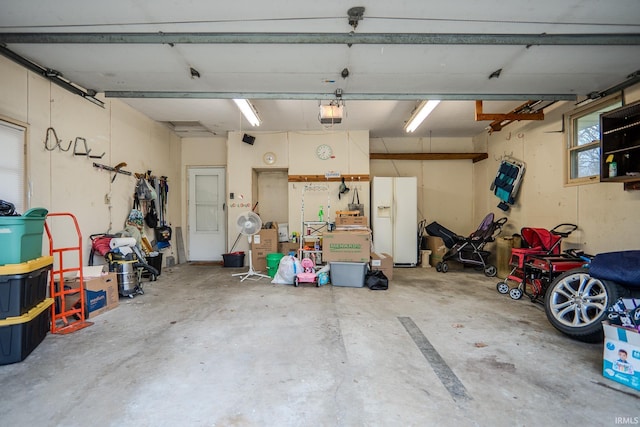 garage with a garage door opener and white fridge with ice dispenser