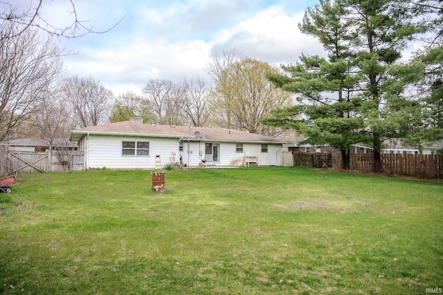 back of property with a yard and a fenced backyard