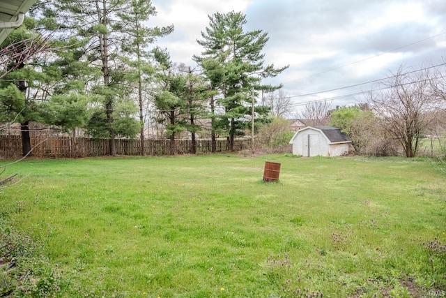 view of yard with fence, a storage shed, and an outdoor structure