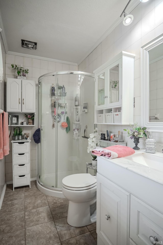 bathroom featuring toilet, vanity, a stall shower, and a textured ceiling