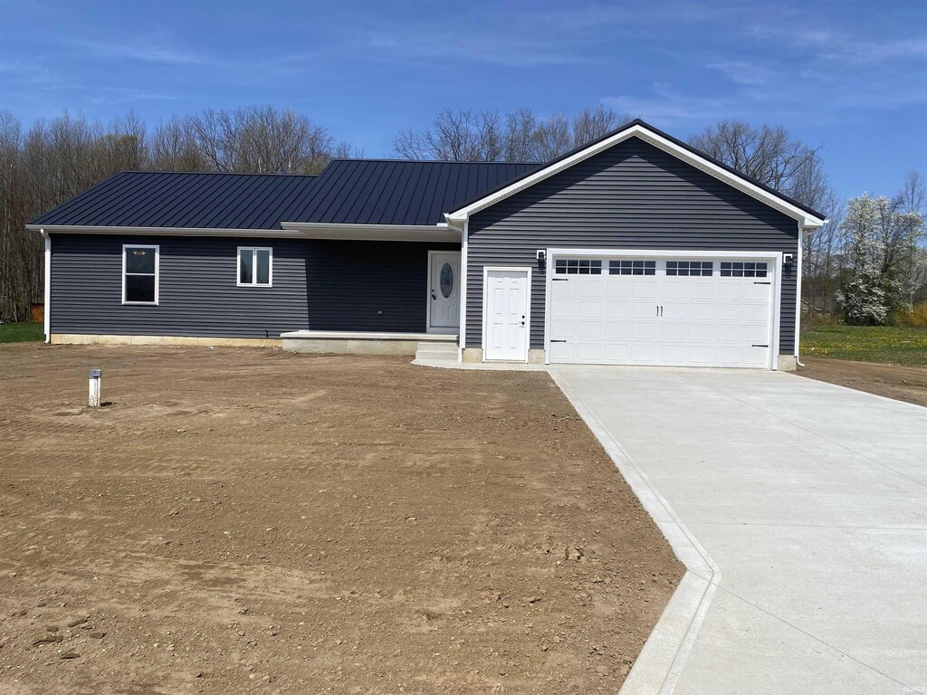 11889 Red Bud Dr, Plymouth, IN 46563 - single story home with concrete driveway, metal roof, and an attached garage