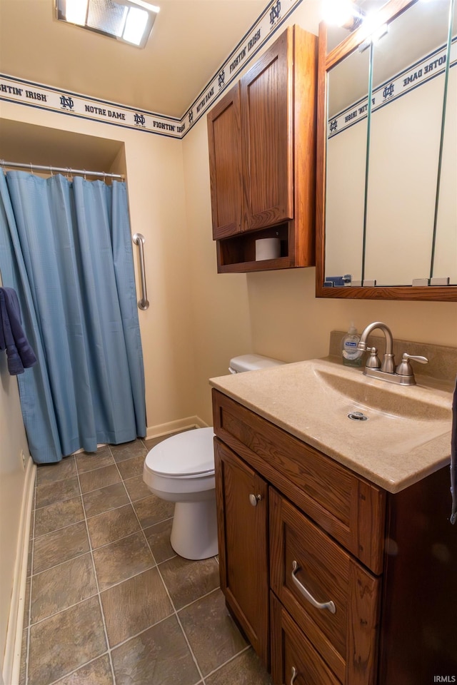 bathroom featuring vanity, toilet, and baseboards