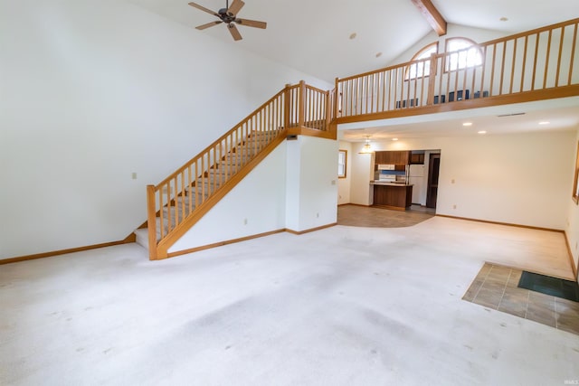 unfurnished living room featuring ceiling fan, high vaulted ceiling, stairs, light carpet, and baseboards