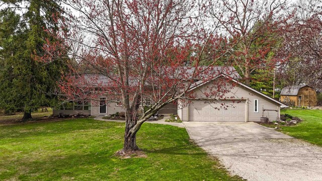 view of front of home with driveway, an attached garage, and a front lawn