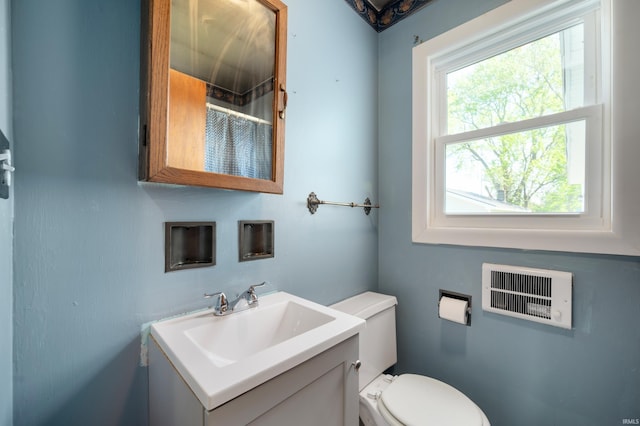 full bathroom featuring toilet, curtained shower, vanity, and visible vents