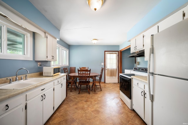 kitchen with white cabinets, a sink, light countertops, under cabinet range hood, and white appliances