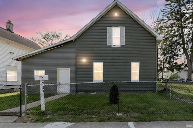 property exterior at dusk with fence and a yard