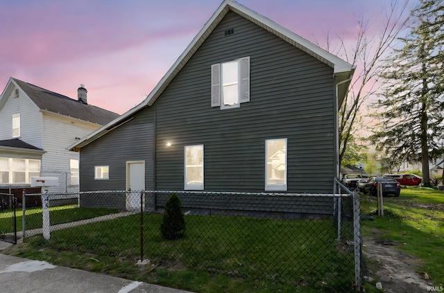 view of property exterior with fence private yard and a lawn