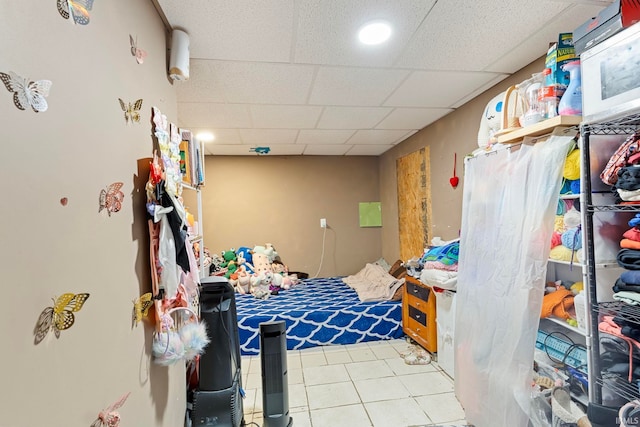 bedroom with a drop ceiling and tile patterned floors