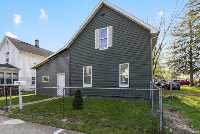 view of side of property featuring fence and a yard