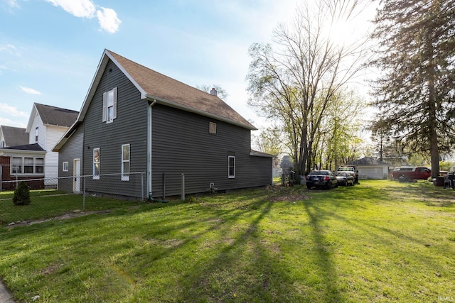 view of side of property featuring fence and a yard