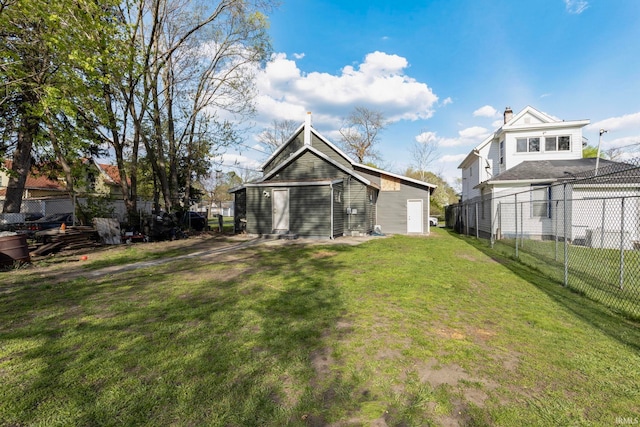 rear view of property with fence and a lawn