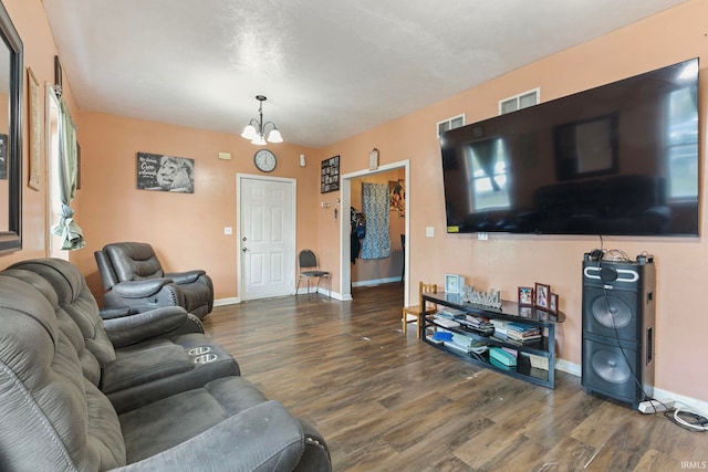 living room with visible vents, a notable chandelier, wood finished floors, and baseboards