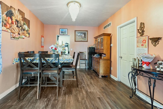 dining area with baseboards, visible vents, and dark wood-type flooring