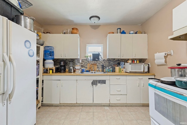 kitchen with tasteful backsplash, white appliances, light countertops, a sink, and white cabinetry