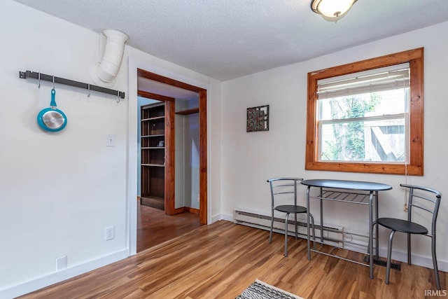 dining area featuring wood finished floors, baseboards, and a textured ceiling