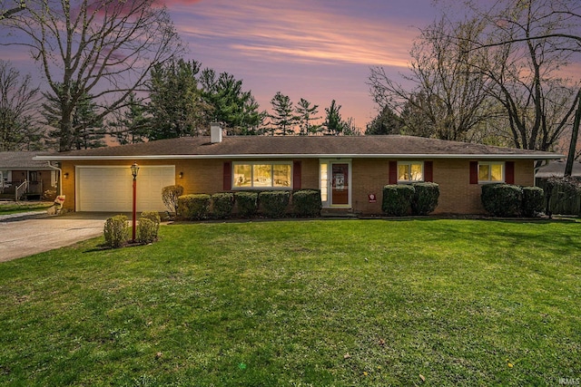 ranch-style home with brick siding, a front yard, driveway, and an attached garage
