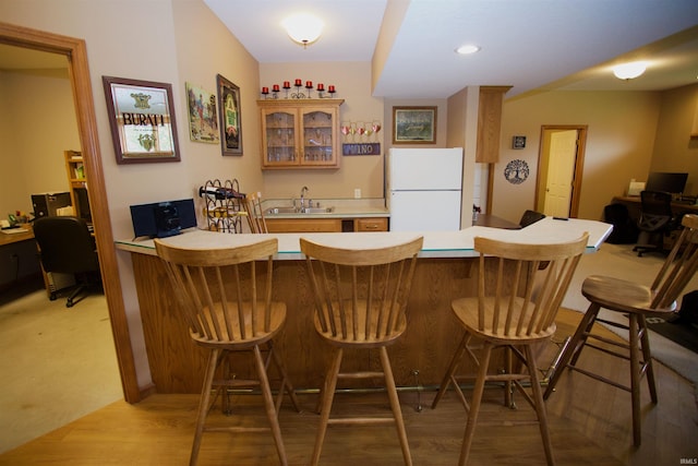 bar featuring a sink, light wood-style floors, indoor wet bar, and freestanding refrigerator