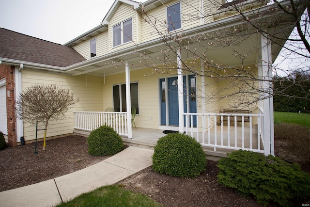 exterior space with covered porch and roof with shingles