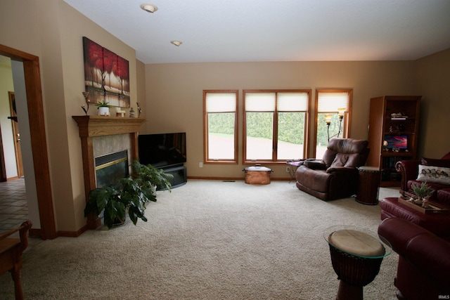 carpeted living area with baseboards and a glass covered fireplace