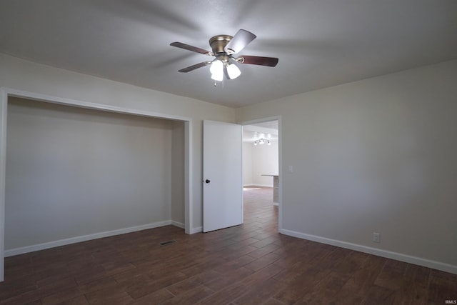 unfurnished room featuring a ceiling fan, dark wood-style flooring, and baseboards