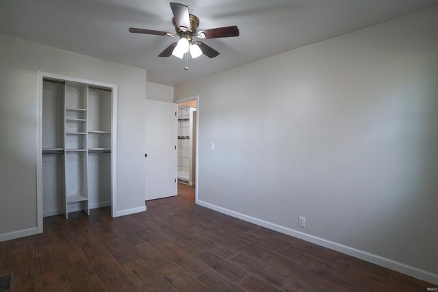 unfurnished bedroom with visible vents, a closet, dark wood-style floors, and baseboards