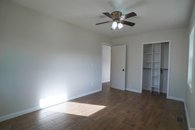 unfurnished bedroom featuring a closet, visible vents, dark wood-style flooring, and baseboards