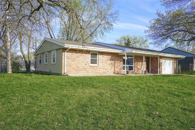 view of front of property with an attached garage, a front yard, and brick siding