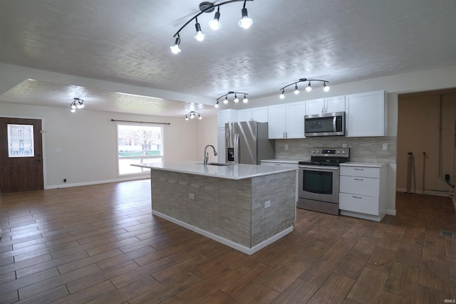 kitchen featuring dark wood-type flooring, a sink, appliances with stainless steel finishes, and light countertops