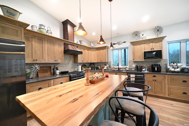 kitchen featuring lofted ceiling, black microwave, fridge, gas range oven, and backsplash
