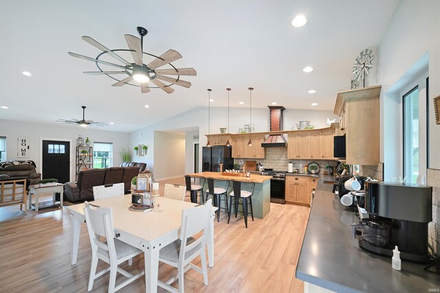 dining space featuring recessed lighting, a ceiling fan, light wood-style flooring, and vaulted ceiling