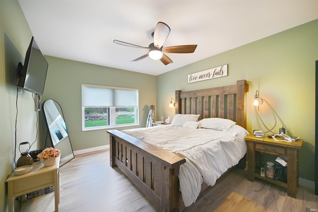 bedroom featuring baseboards, ceiling fan, and light wood-style flooring