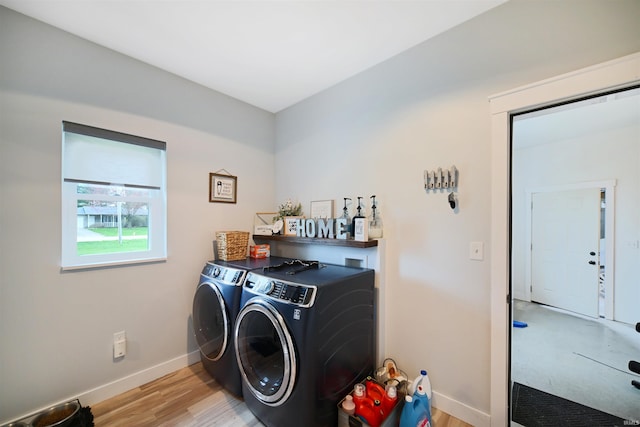 laundry area featuring baseboards, light wood-type flooring, separate washer and dryer, and laundry area