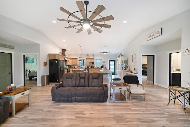living room featuring a ceiling fan, light wood finished floors, and vaulted ceiling