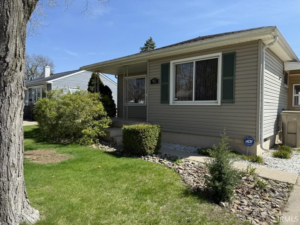 view of front of home with a porch and a front yard