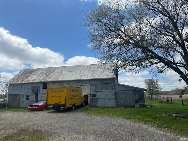 view of barn featuring driveway and a yard